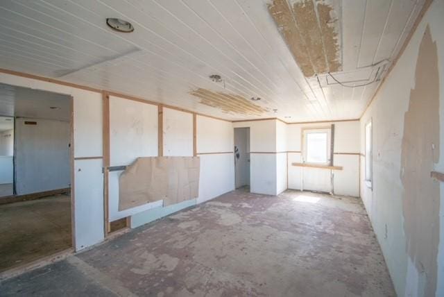 empty room with concrete floors and wooden ceiling