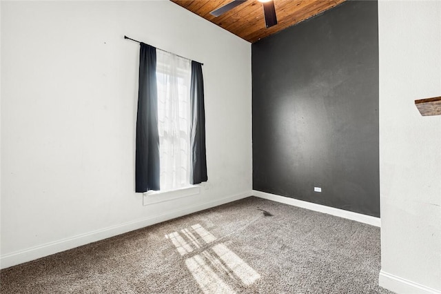 carpeted spare room with ceiling fan and wood ceiling