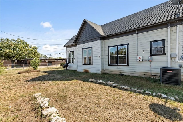 view of side of home featuring a lawn and cooling unit