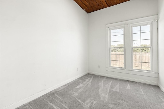 carpeted empty room featuring wooden ceiling