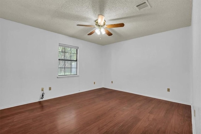 unfurnished room with a textured ceiling, ceiling fan, and dark wood-type flooring