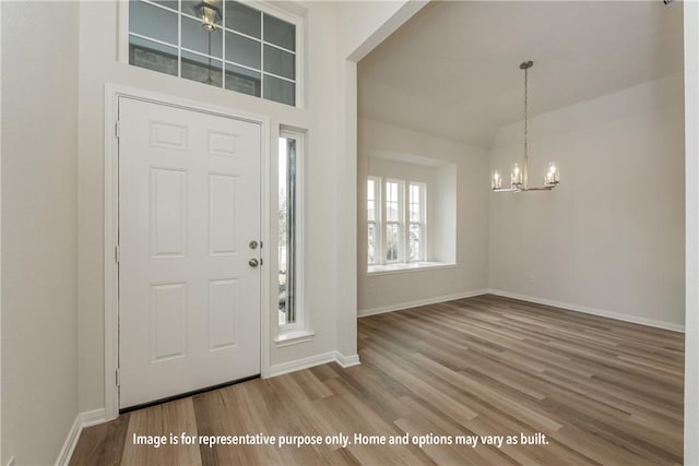 entryway featuring hardwood / wood-style flooring and a chandelier