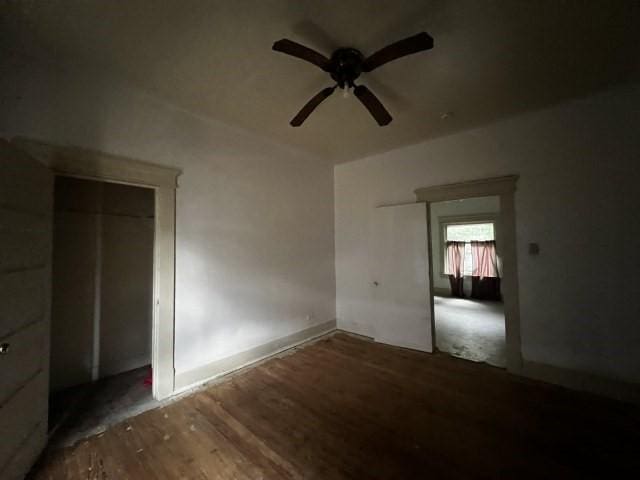 empty room with dark hardwood / wood-style flooring and ceiling fan