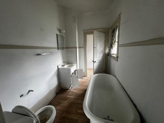 bathroom featuring a bathtub, vanity, hardwood / wood-style floors, and toilet