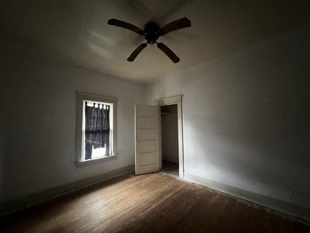 empty room with ceiling fan and hardwood / wood-style floors