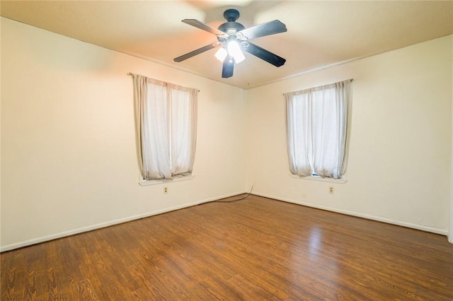 empty room with dark hardwood / wood-style flooring and ceiling fan