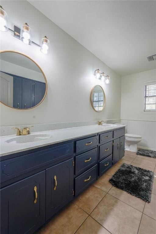 bathroom with tile patterned flooring, vanity, and toilet