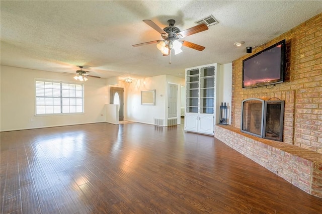 unfurnished living room featuring a textured ceiling, dark hardwood / wood-style floors, ceiling fan, and a fireplace