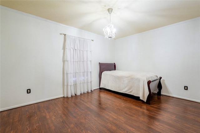 bedroom with a notable chandelier, dark hardwood / wood-style floors, and ornamental molding