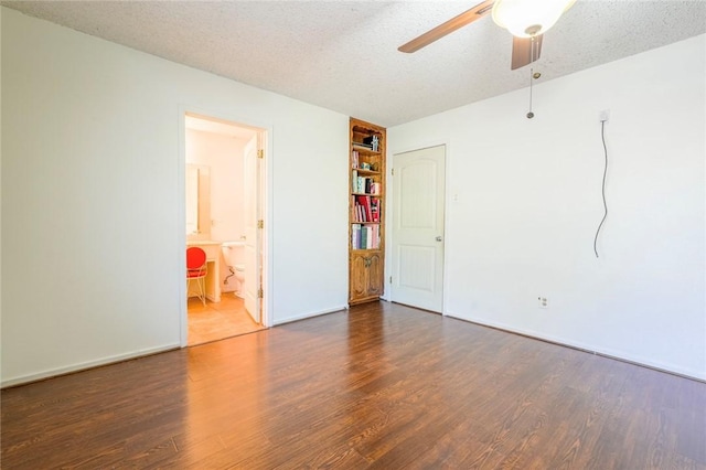 unfurnished room with ceiling fan, dark hardwood / wood-style flooring, and a textured ceiling