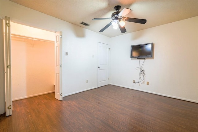 unfurnished bedroom featuring dark hardwood / wood-style floors and ceiling fan