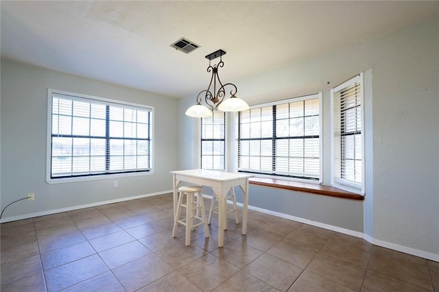 unfurnished dining area with tile patterned floors, plenty of natural light, and an inviting chandelier