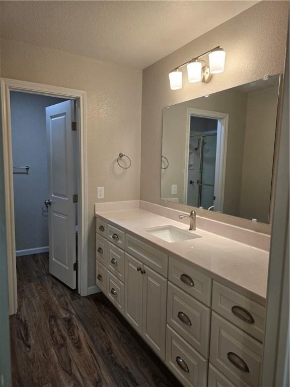 bathroom with a textured ceiling, vanity, and hardwood / wood-style flooring