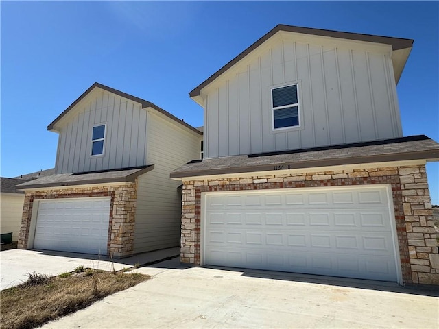 view of front of home featuring an attached garage, driveway, board and batten siding, and roof with shingles