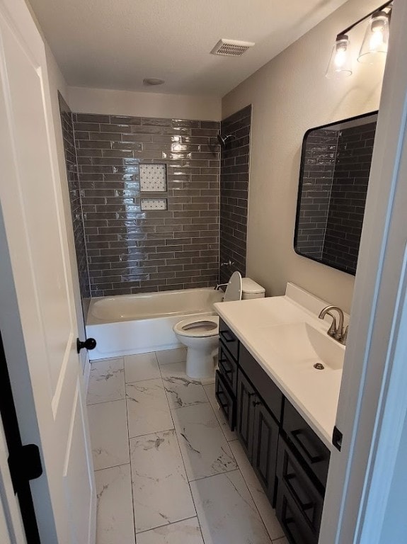 full bathroom with tiled shower / bath combo, vanity, and toilet