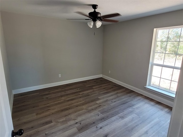 spare room with ceiling fan, dark wood-type flooring, and a healthy amount of sunlight