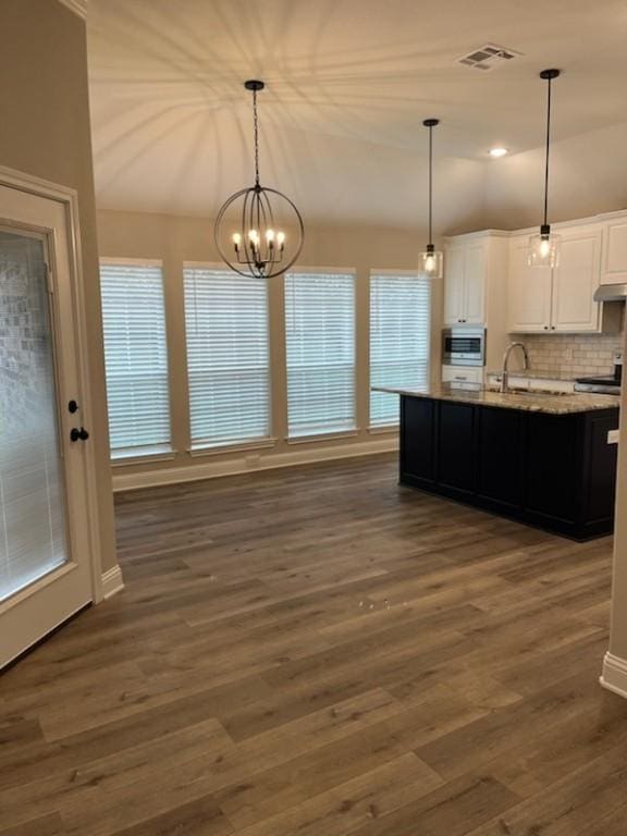 kitchen with hanging light fixtures, a center island with sink, white cabinets, and dark hardwood / wood-style flooring