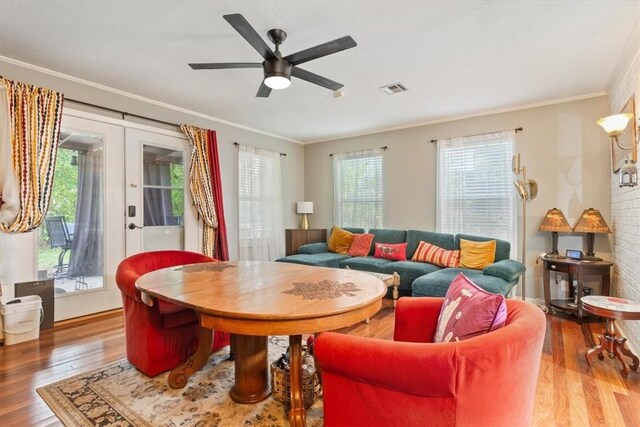 living room with hardwood / wood-style flooring, a healthy amount of sunlight, and crown molding