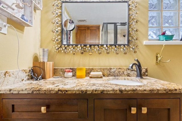 bathroom with vanity and a shower with shower door