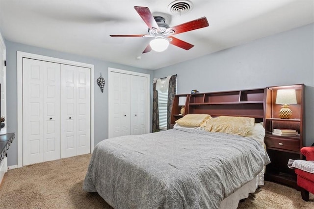 carpeted bedroom with multiple closets and ceiling fan