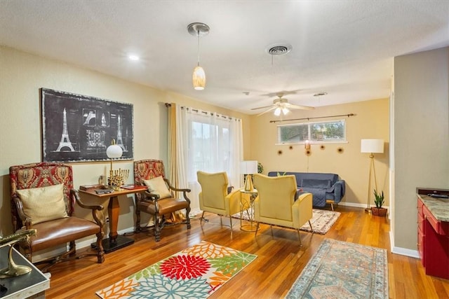 sitting room featuring light hardwood / wood-style flooring, ceiling fan, and a healthy amount of sunlight