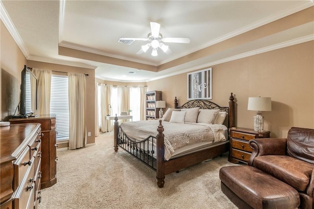 carpeted bedroom with ceiling fan, a raised ceiling, and ornamental molding