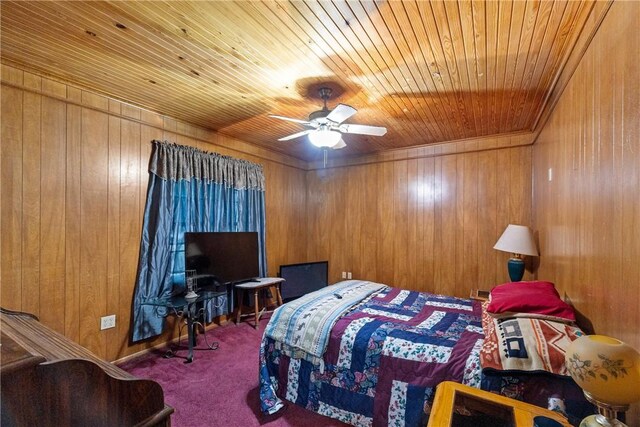 carpeted bedroom with ceiling fan, wood walls, and wooden ceiling