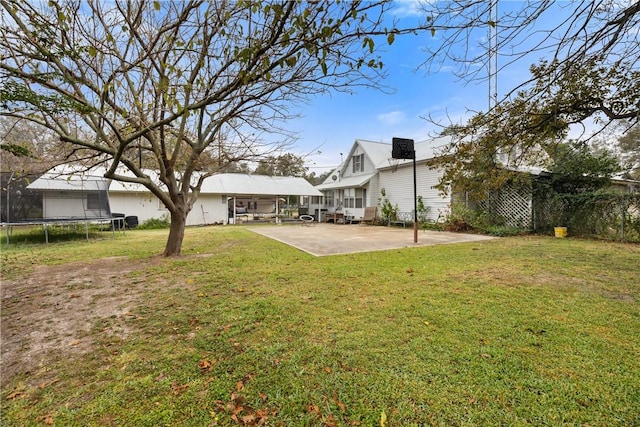 view of yard with a trampoline and a patio area