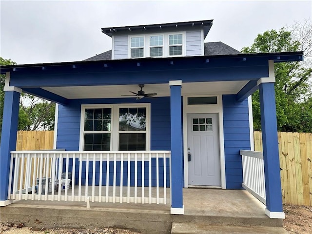 view of front of house with covered porch, a shingled roof, a ceiling fan, and fence