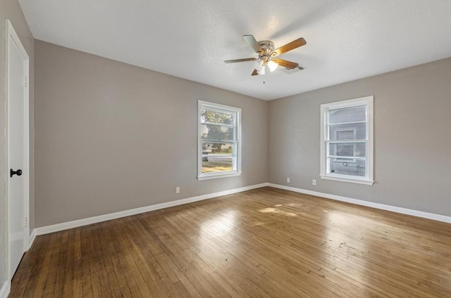 empty room with hardwood / wood-style floors and ceiling fan