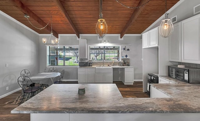 kitchen with dark wood-type flooring, white cabinets, and hanging light fixtures