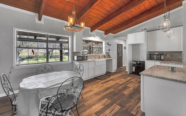 kitchen featuring light stone countertops, white cabinetry, dark wood-type flooring, vaulted ceiling with beams, and a chandelier