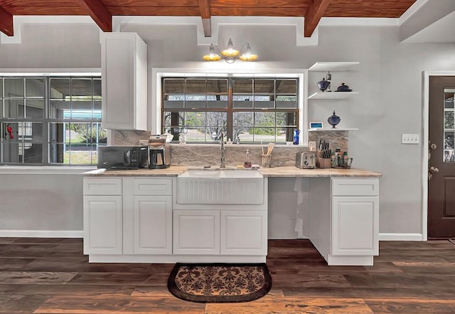 kitchen with backsplash, dark wood-type flooring, sink, beam ceiling, and white cabinetry