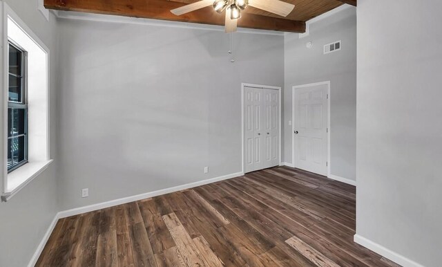 empty room with beam ceiling, dark hardwood / wood-style floors, high vaulted ceiling, and ceiling fan