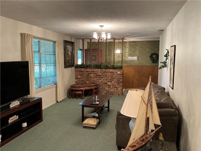 living room featuring carpet flooring, wooden walls, a chandelier, and a textured ceiling