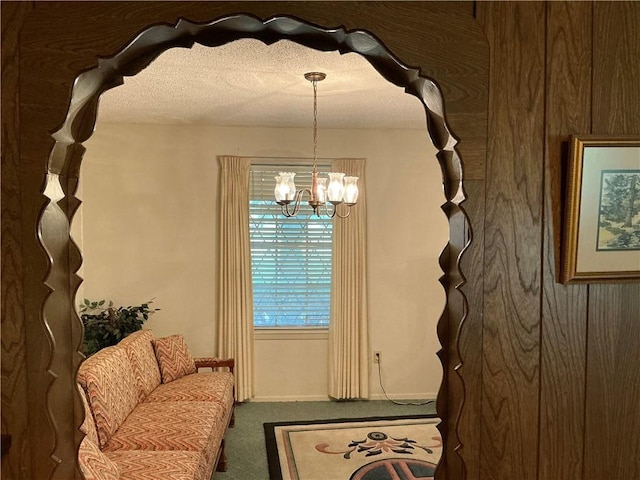 sitting room featuring carpet flooring, a textured ceiling, and a notable chandelier