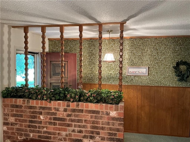 interior space with a textured ceiling and wooden walls