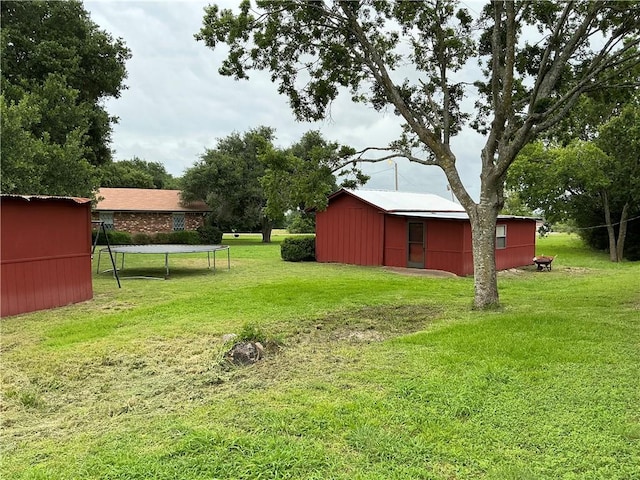 view of yard with an outdoor structure and a trampoline