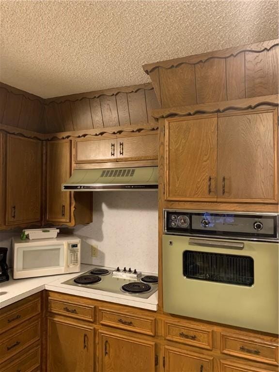 kitchen featuring white appliances and a textured ceiling