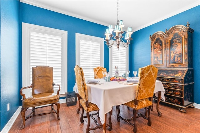 dining room featuring crown molding, wood finished floors, baseboards, and a chandelier