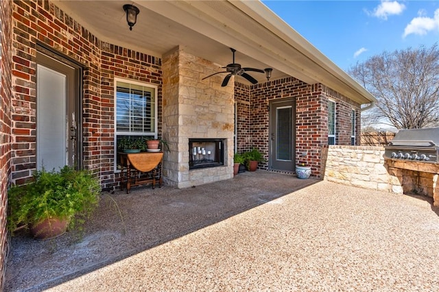 view of patio featuring an outdoor kitchen, a grill, an outdoor stone fireplace, and ceiling fan