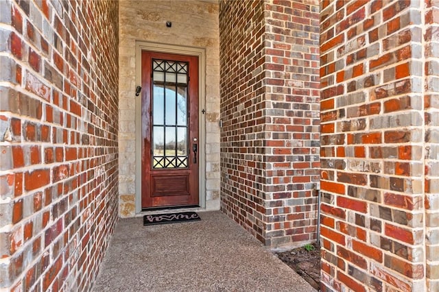 entrance to property featuring brick siding