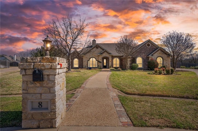 french provincial home featuring a yard and a chimney