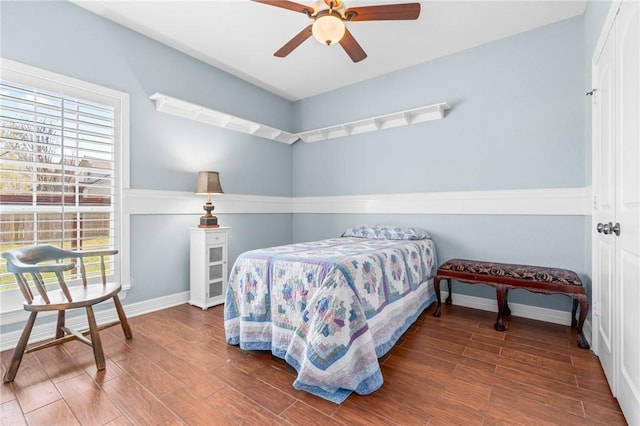 bedroom featuring a ceiling fan, baseboards, and wood finished floors