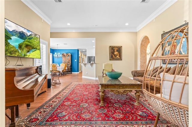 living area with visible vents, crown molding, recessed lighting, an inviting chandelier, and wood finished floors