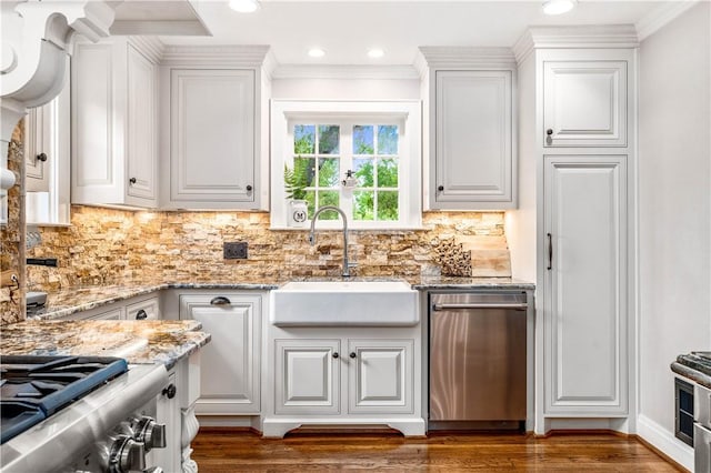 kitchen with backsplash, white cabinetry, and sink