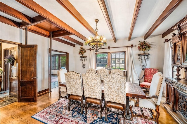 dining space featuring beamed ceiling, light hardwood / wood-style floors, and an inviting chandelier