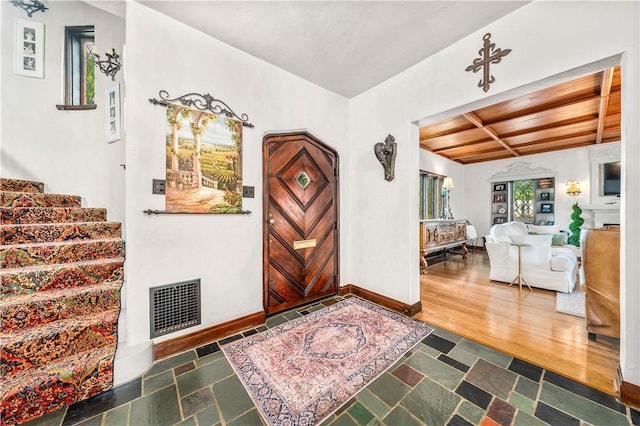 entryway featuring beamed ceiling, dark hardwood / wood-style floors, and wood ceiling