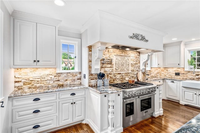 kitchen featuring white cabinetry, range with two ovens, and a healthy amount of sunlight