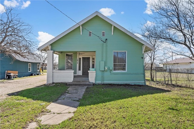 bungalow-style home featuring a porch, fence, and a front lawn